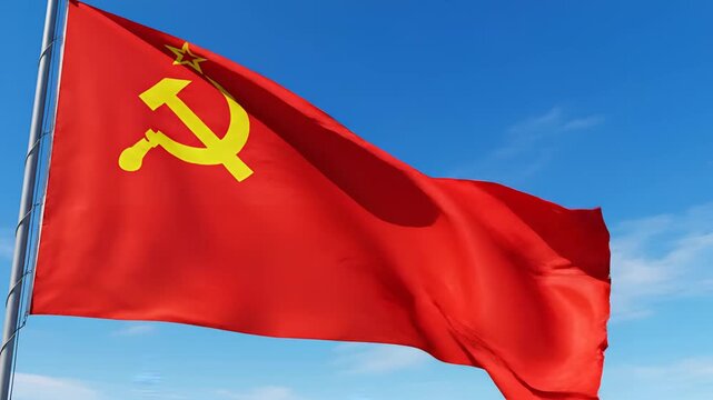 Red flag with hammer and sickle symbol waving against blue sky.