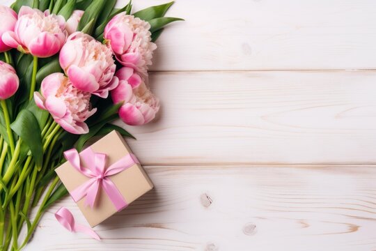 Pink peonies and a gift box with a ribbon creating a celebration background