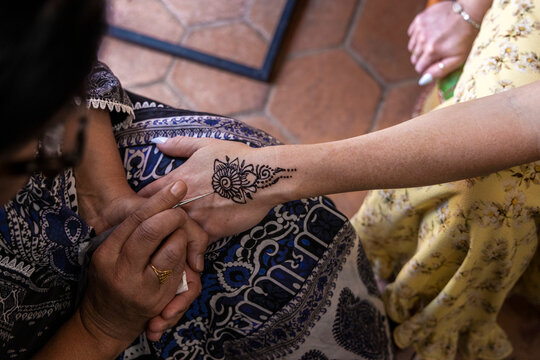 Looking down on hands painting henna art