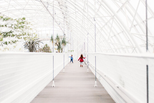 Two Children Walking On Bridge in Gardens