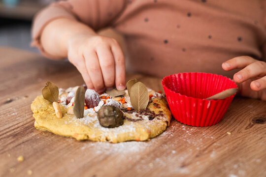 Toddler making a nature pie with dough and leaves