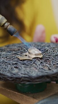 Jeweler using a blowtorch to solder a small silver piece