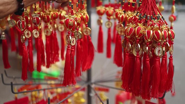Traditional Vietnamese Tet holiday decoration close up. Red and golden lucky feng shui charms with Wu Lou gourds, coins and tassels for Lunar New Year at a street market in Nha Trang, Vietnam.