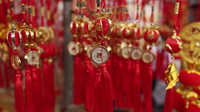 Traditional Vietnamese Tet holiday decoration close up. Red and golden lucky feng shui charms with oriental coins and tassels for Lunar New Year at a street market in Nha Trang, Khanh Hoa, Vietnam.