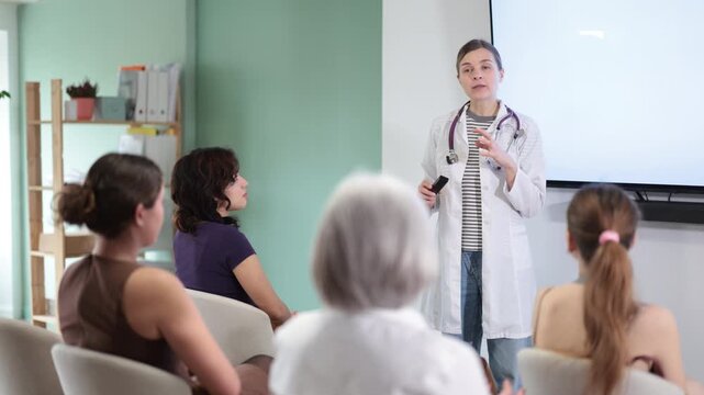 Woman doctor speaks to audience of listeners, carry out lecture. Students attend offline lectures, sit and listen to report, additional and compulsory education, first aid help course