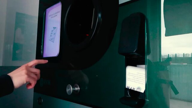 Person Taking a Voucher from a Reverse Vending Machine for Recycling