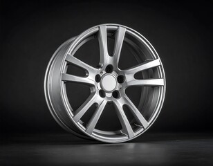 Obraz premium Metallic car wheel isolated against dark background for automotive design