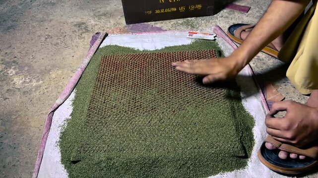 Person Grinding Gunpowder Into Bullet Casings at Factory