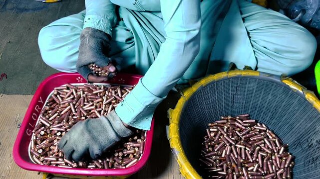 Ammunition Factory Worker Manually Sorting Bullet Cartridges