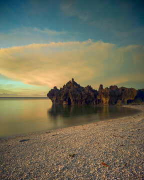 Golden Calm at Tiang Bendera Beach, Rote Island &mdash; where rugged coral cliffs rest beneath a glowing tropical sky