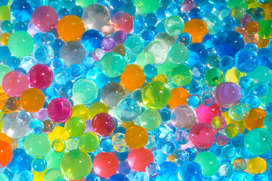 Colorful transparent water beads background with vibrant gel spheres texture