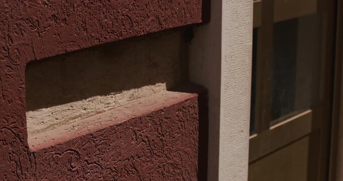 Close-up detail of a textured building facade and window frame on Sergius Street.