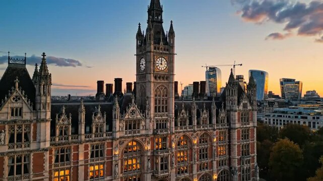 Aerial view of a grand historic building in London with a clock tower during sunset