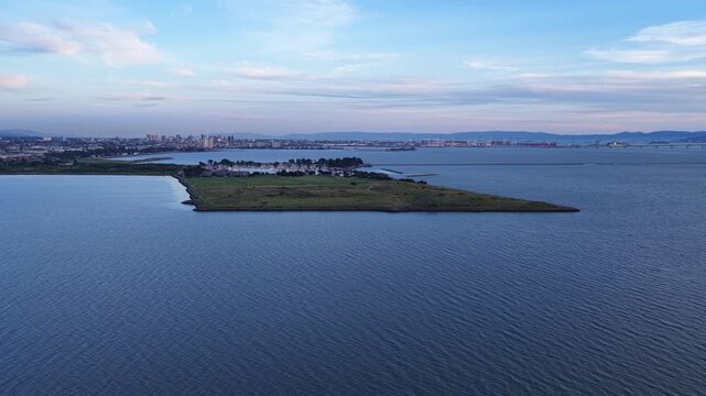 Aerial drone view of Cesar Chavez Park in Berkeley California, on the east shore of San Francisco bay, with the city skyline in the background during a beautiful and colorful sunset