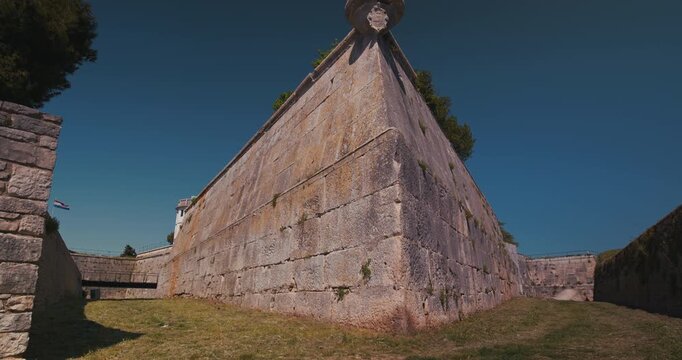 Corner stone fortress wall with grassy ground at Pula Castle.