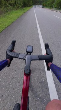 POV shot of a cyclist on an open road, showcasing handlebars and speedometer, symbolizing adventure and freedom.