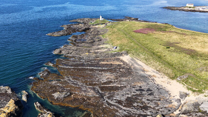 Obraz premium Aerial View of a Coastal Lighthouse and Rocky Shoreline in Fife