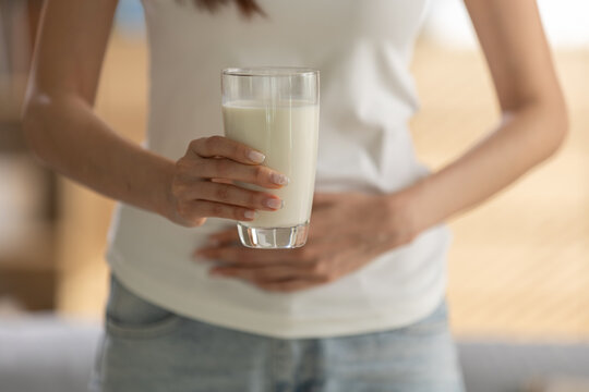 Woman with lactose intolerance feeling stomach pain and ache from dairy milk. health problem concept showing discomfort, bloating, and food allergy symptom from drink