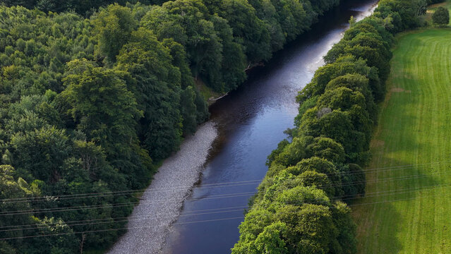 Aerial View of a Tranquil River Flowing Through Scottish Highland Forest