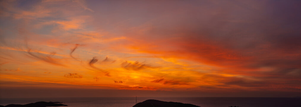 A panoramic view of the dramatic sky during a spectacular sunset over the sea
