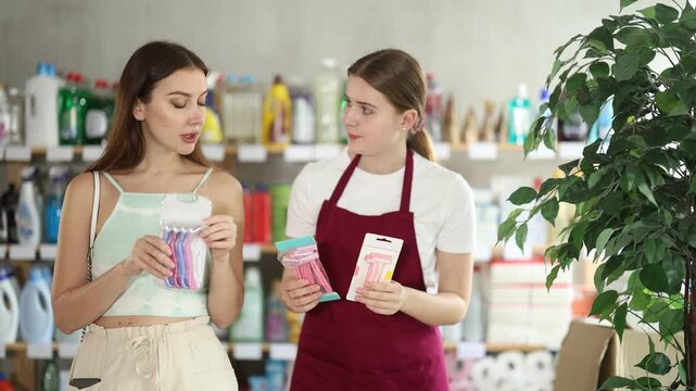 Saleswoman offers different sets of razors to a female buyer. European woman chooses hair removal razors with the help of a sales consultant in the summer. High quality 4k footage