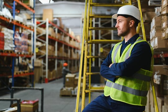 Shipment manager verifying all merchandise pallets in depot, providing merchandise distribution for retail store. Employee walking around boxes of manufactured products, dispatch notes