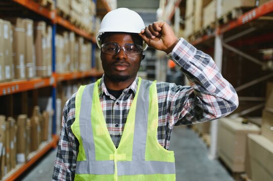Portrait of a handsome african american warehouse worker in overalls and a helmet