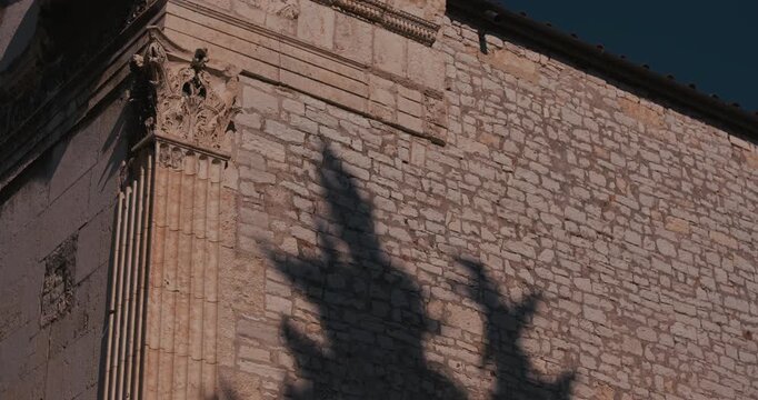 Close-up view of the Temple of Augustus stone facade with Corinthian column detail and shadows.