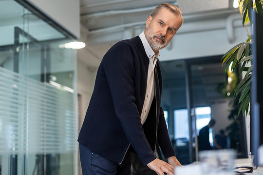 Smiling businessman manager executive standing in office