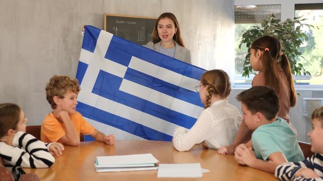 Teacher with flag of Greece tells story of the emergence of the state. High quality 4k footage