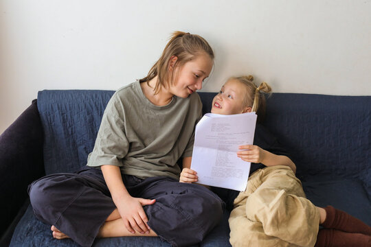 Smiling sibling learning a role for the school drama club at home
