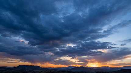 Fototapeta premium Vast Sunset Sky with Bold Blue Cloud Formation Panoramic Background