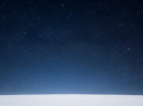 A breathtaking night sky filled with countless stars shining brightly against a deep blue and black gradient background above a snowy landscape