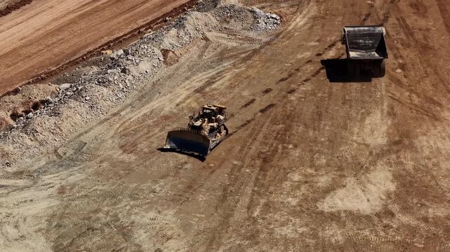Aerial of tractor pushing dirt in mining pit in Utah