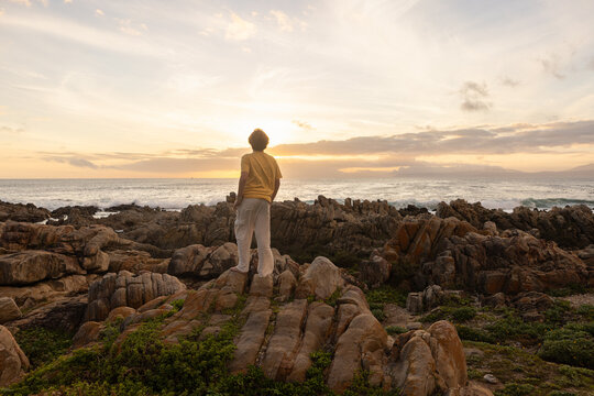 young boy exploring  rocky coastline of DeKelders, Gansbaai, South Africa