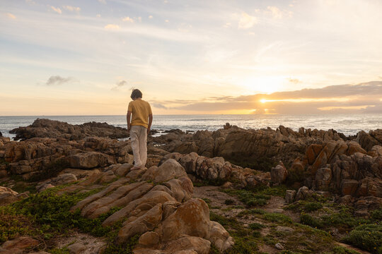 young boy exploring  rocky coastline of DeKelders, Gansbaai, South Africa