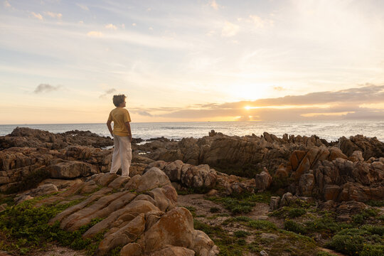 young boy exploring  rocky coastline of DeKelders, Gansbaai, South Africa
