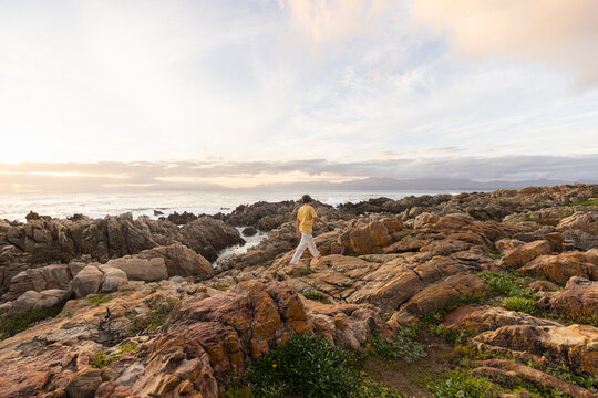 young boy exploring  rocky coastline of DeKelders, Gansbaai, South Africa