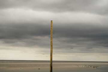 Piquet jaune sur paysage de mer et ciel tourmenté à Berck-sur-Mer dans le Pas-de-Calais en France © Pause Papote