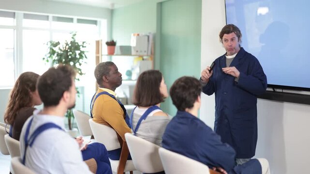Middle aged man worker lecturer speaks to audience of listeners, shares knowledge, communicates with listeners. Lecture on changes in labor legislation, trade union meeting