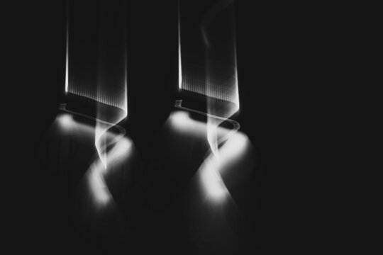 Vertical white light beams in ICM motion, monochromatic abstract with spectral texture. 