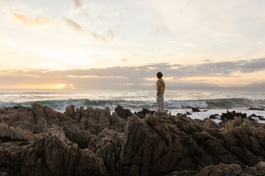 young boy exploring  rocky coastline of DeKelders, Gansbaai, South Africa