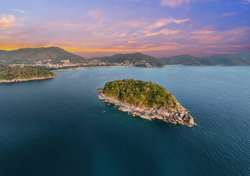 Aerial view shows Ko Pu Island with green trees and rocky shores in the blue Andaman Sea