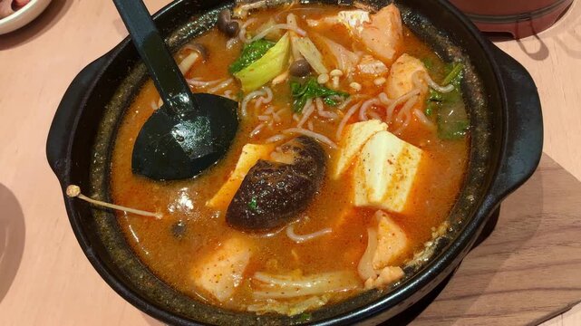 Spicy Salmon Jjigae Korean Stew with Tofu and Enoki Mushroom in Stone Pot, Hot Asian Soup

