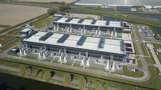 High aerial perspective of a massive cloud computing and server infrastructure campus in the Dutch countryside.