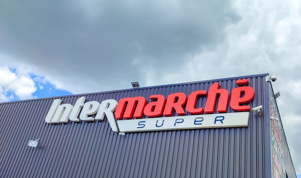 Chatellerault, France - May 15, 2026: Intermarche Super store sign on building exterior with blue sky and clouds in background