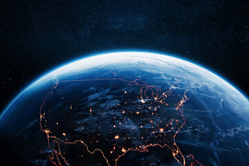 Fototapeta premium breathtaking view of the USA at night from space, displaying glowing major city lights and orange borders on planet Earth's curvature, set against a dark, starry cosmos background