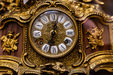 Obraz premium Macro shot of vintage antique bronze clock face with Roman numerals and ornate details