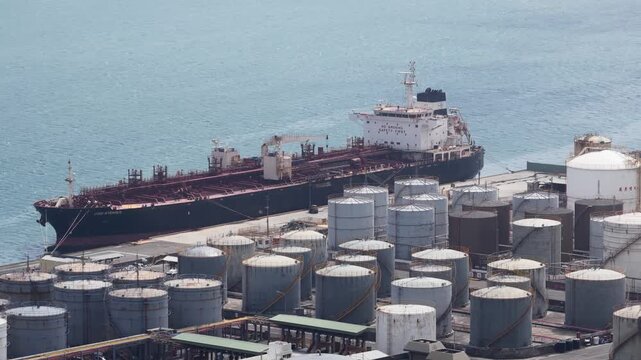 Large oil tanker ship moored at industrial port terminal