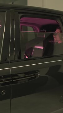 Man Riding in Luxury Car at Night with Pink Neon Interior Light